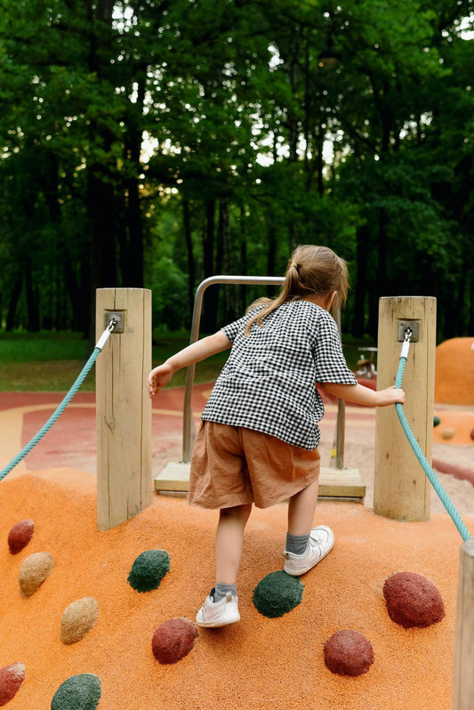 Little toddler girl climbing at the playground